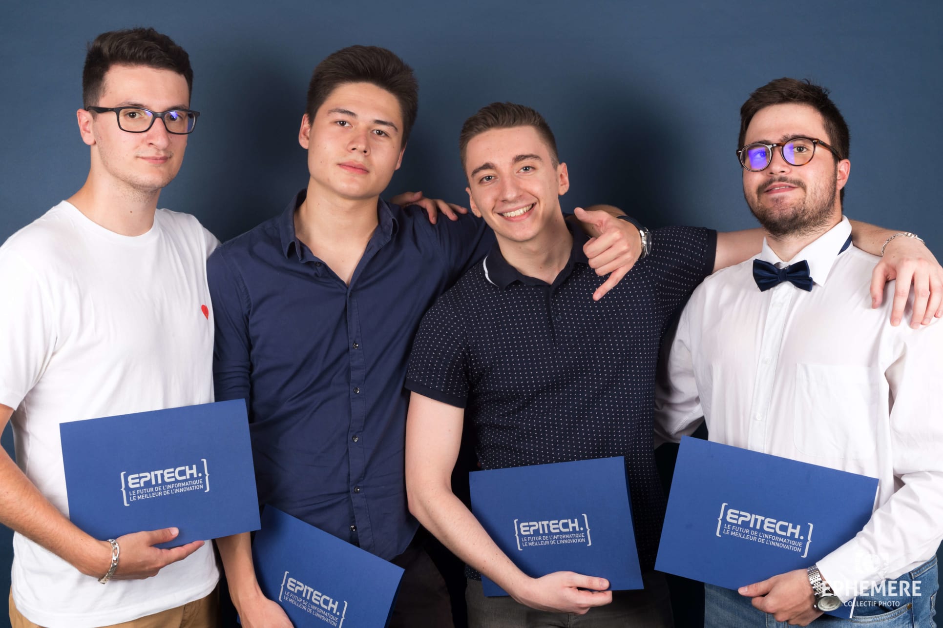 Remy Machado and his friends holding their diplomas